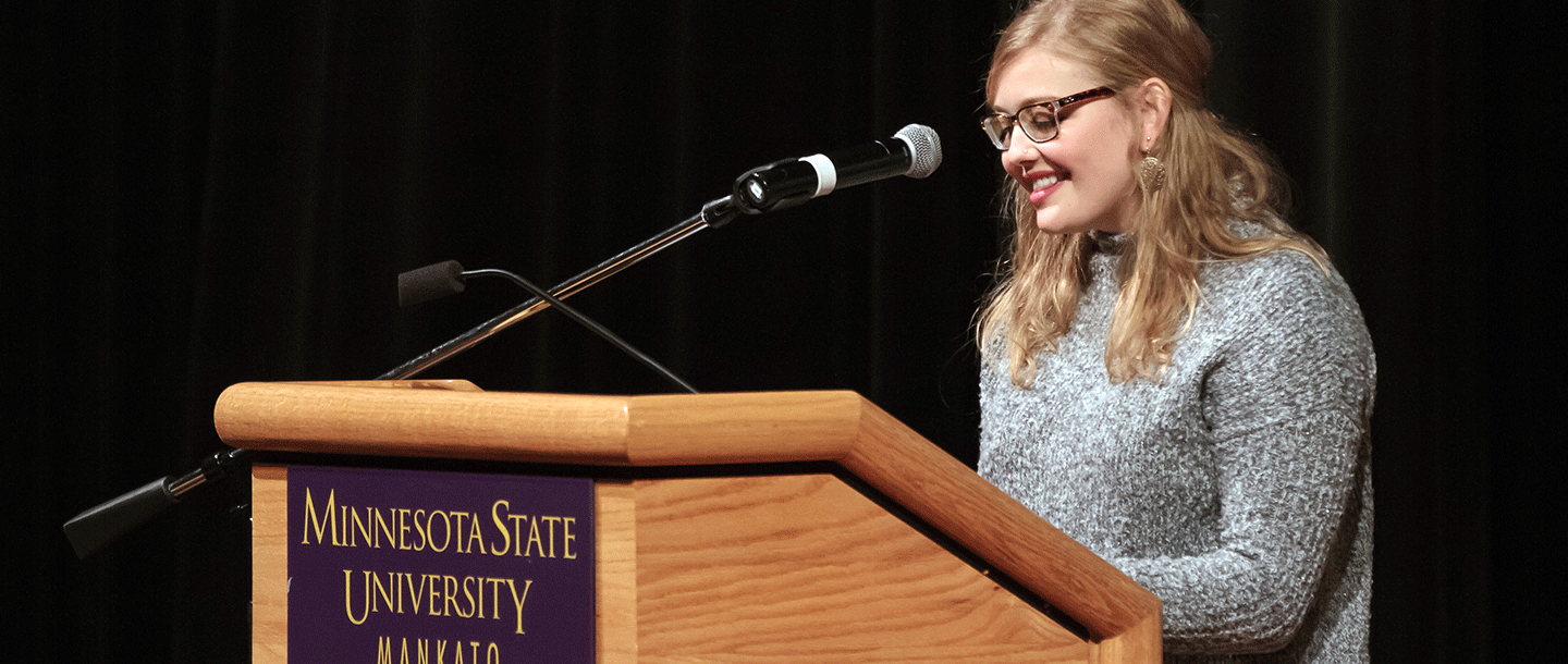 Female student speaking in a mic standing in a MNSU podium