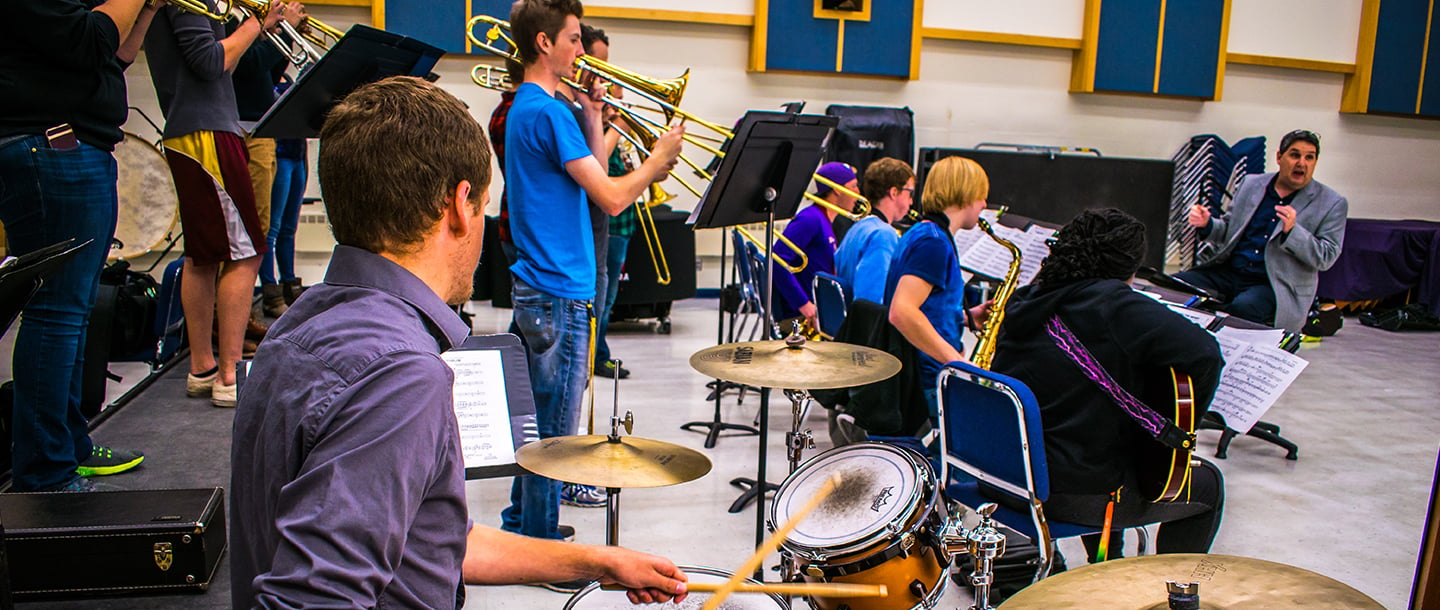 Music instructor conducting a group of band students in the music room