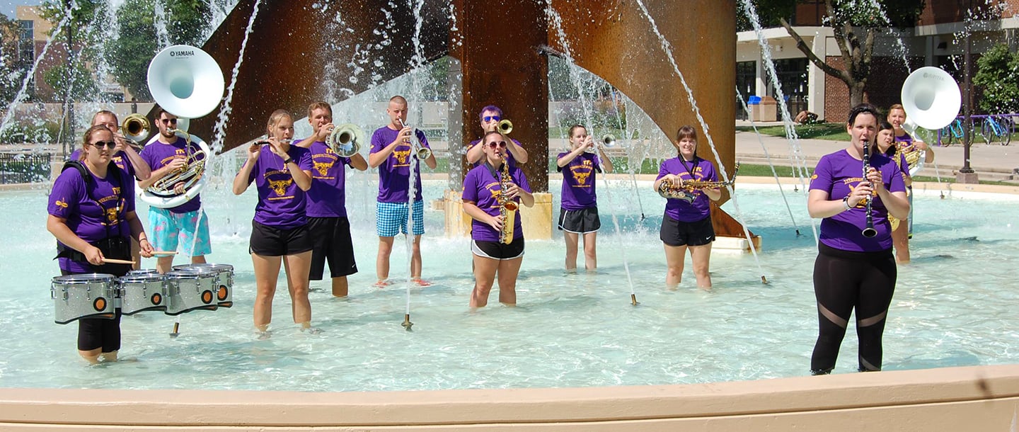 Members of Maverick Machine performing in Worlds Fair Fountain half-filled with water
