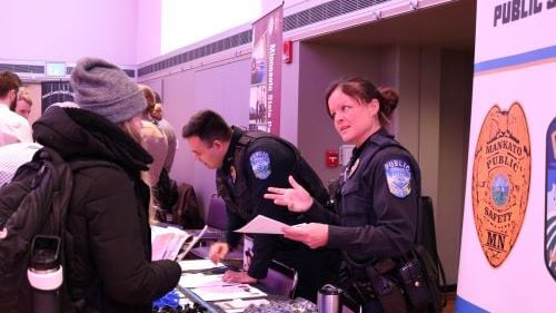 Students talking with Public Safety officers at the public safety booth during the Criminal Justice Career and Internship Fair in the CSU Ballroom