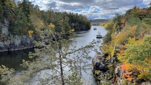 Landscape view of river between cliffs with a river boat near North Shore in Minnesota
