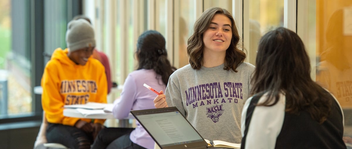 a person holding a pen and smiling