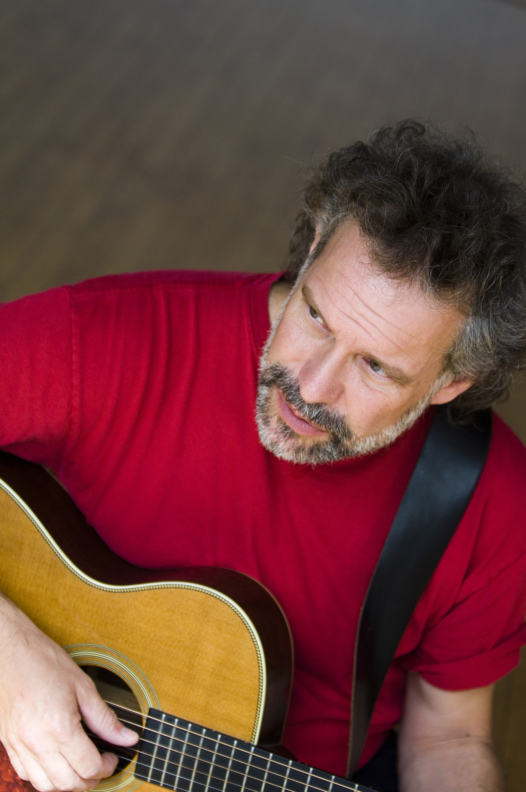 a person in a red shirt holding a guitar