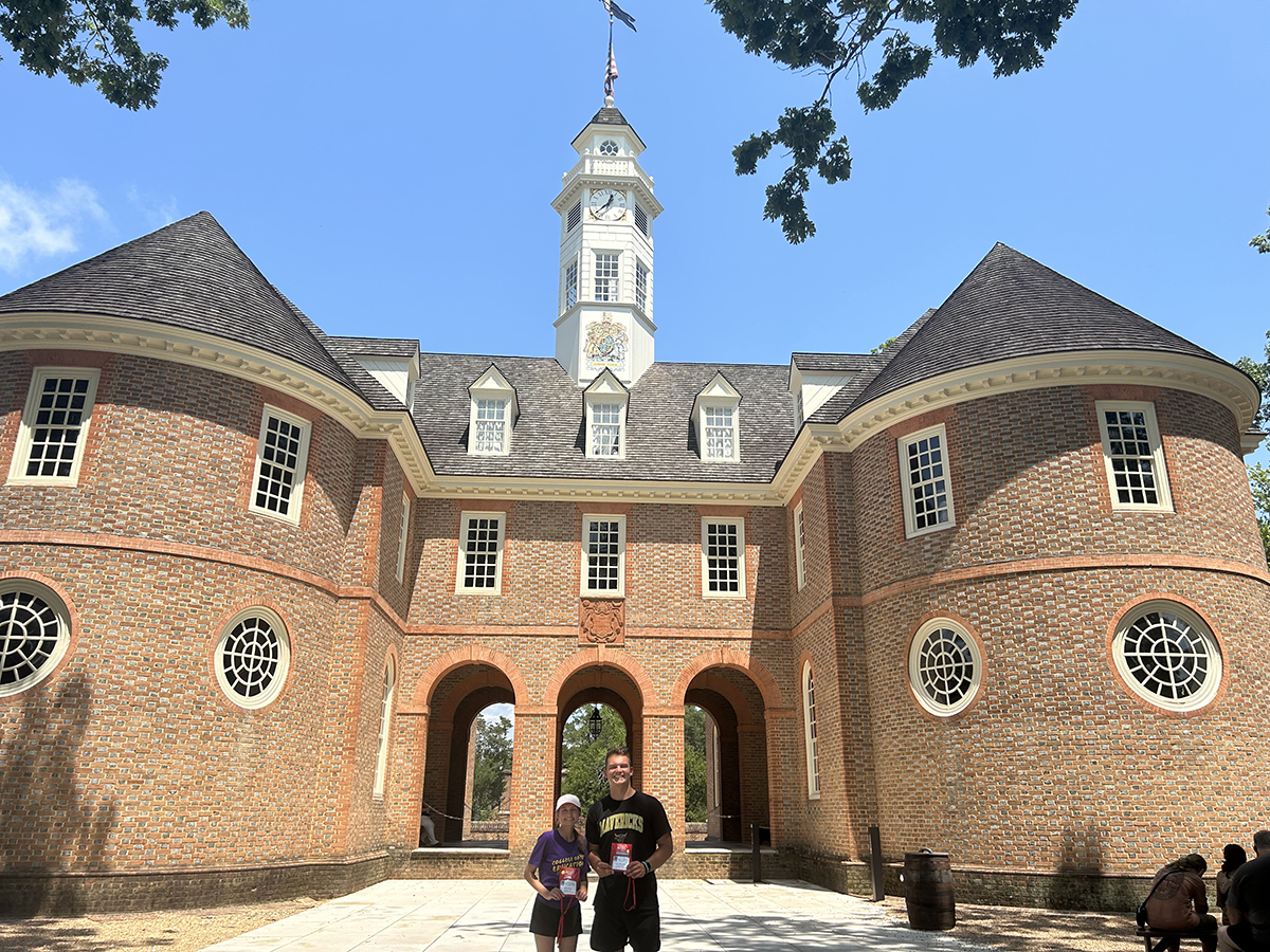Male and female students outside tall building at Colonial Williamsburg