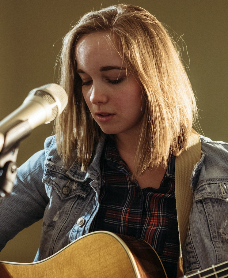 a person with a guitar and a microphone