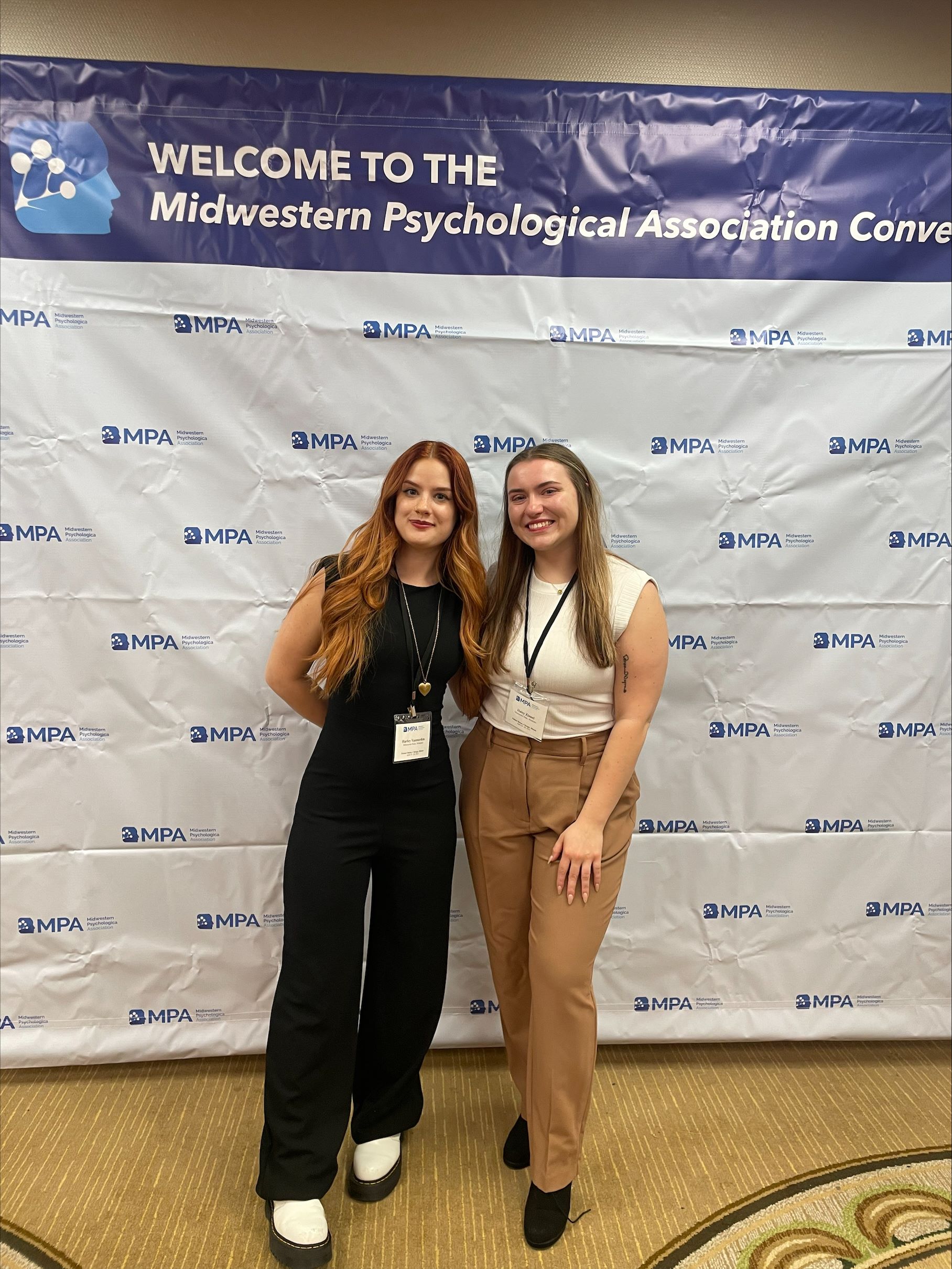 Psychology students standing by conference sign