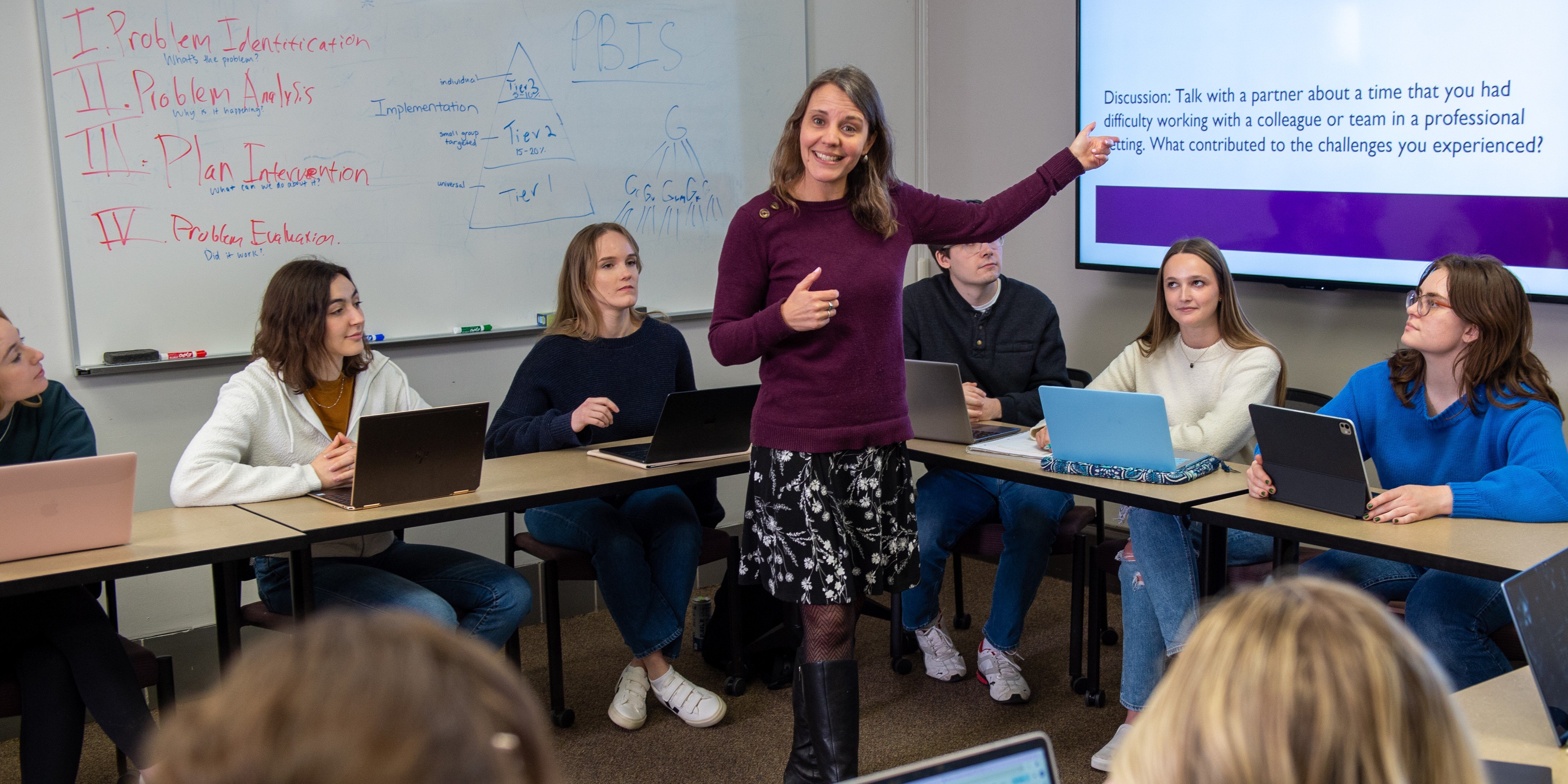 Professor teaching in the middle of the classroom
