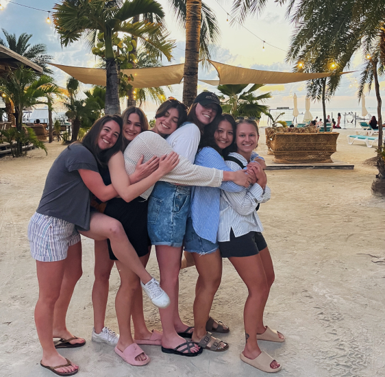 a group of women hugging on a beach