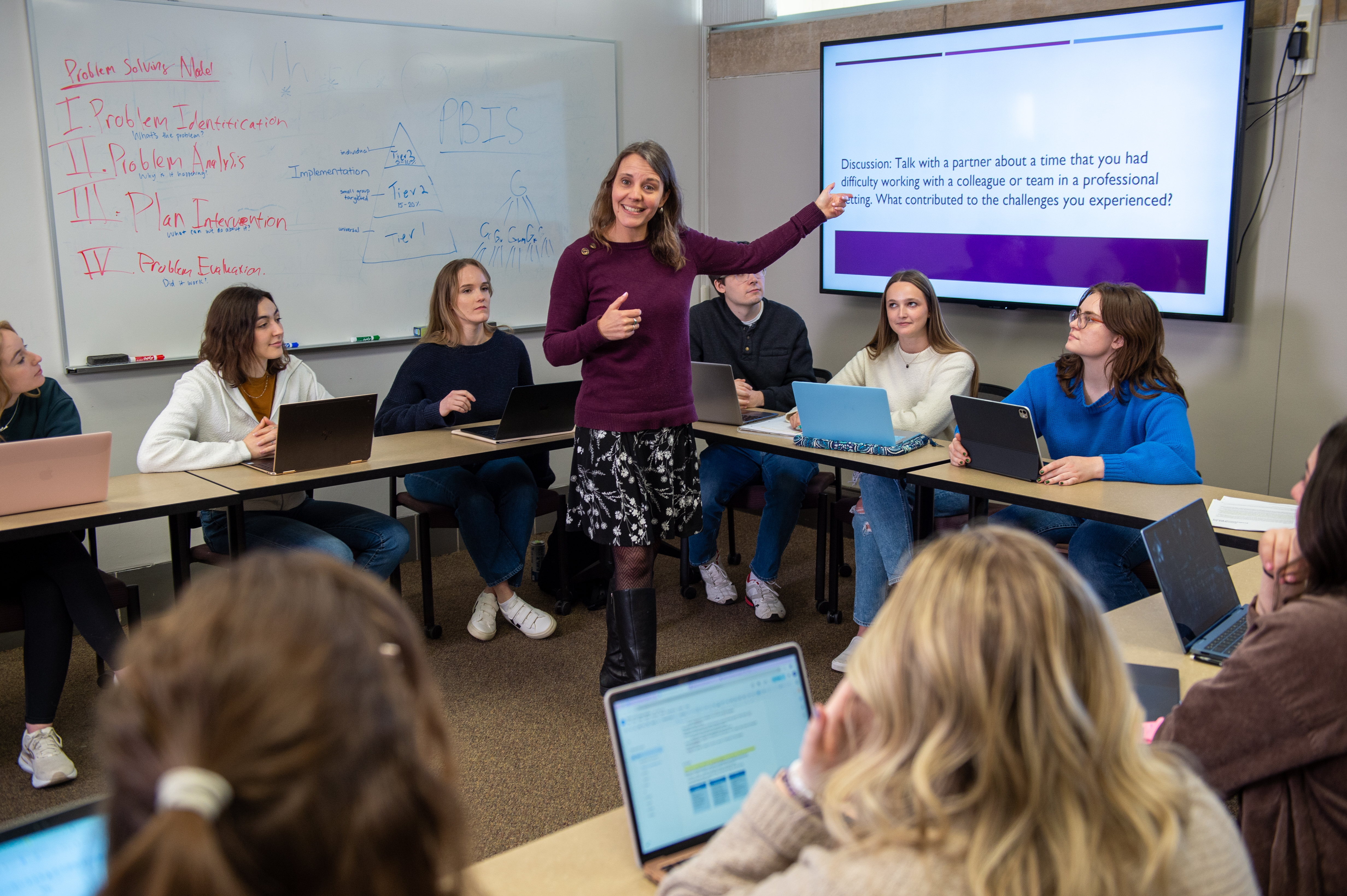 A faculty (a female) teaching to a group of student
