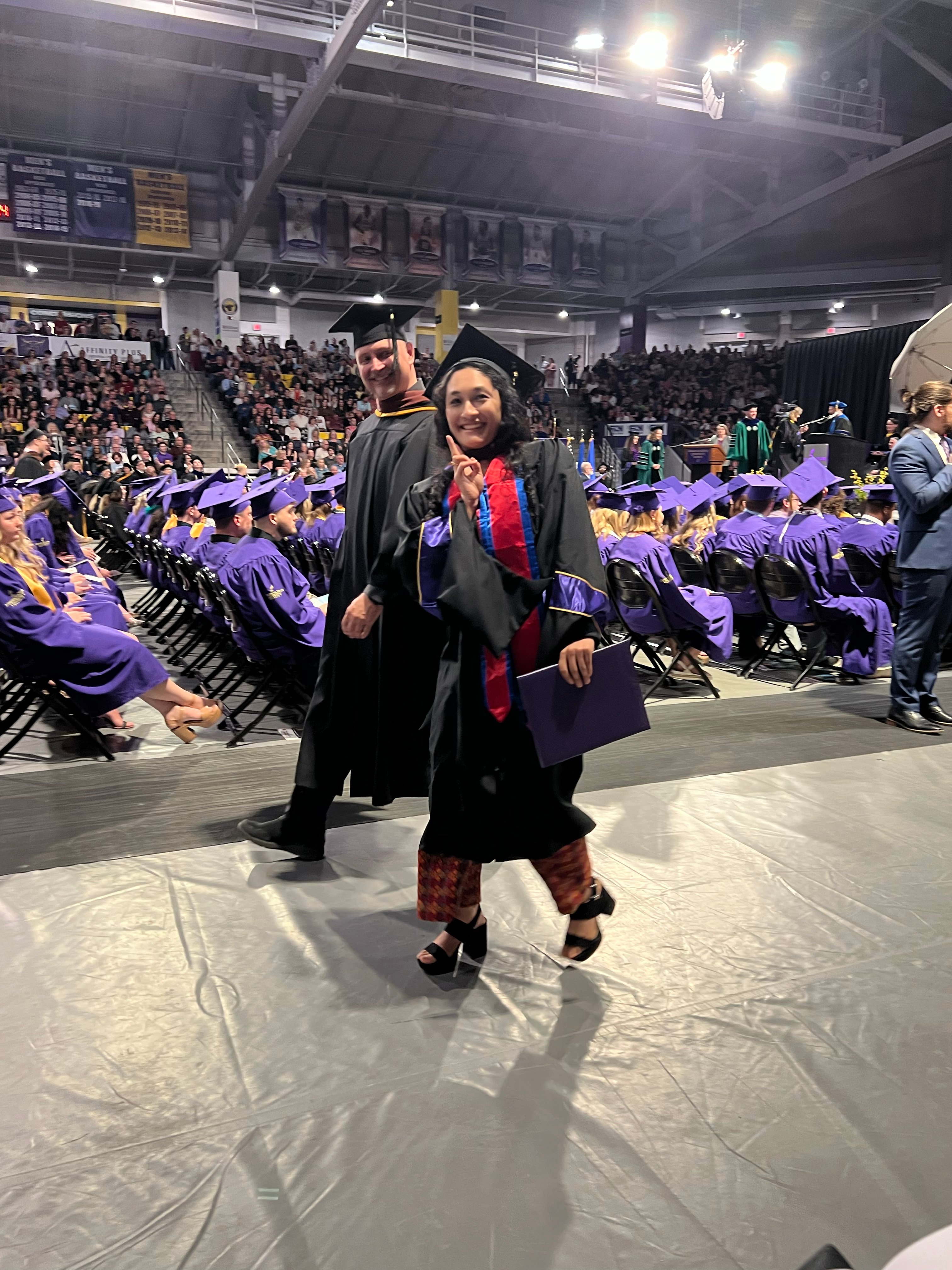 Parisha walks at graduation with Dance Director Daniel Stark