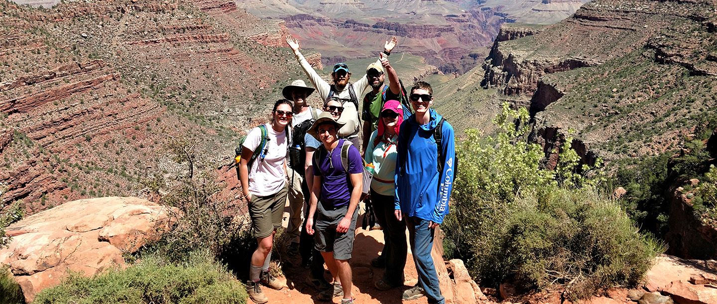 The earth science students posing on a mountain side with the Grand Canyon in the background