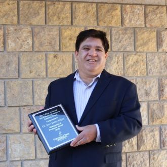 Dr. Lopez posing with his award