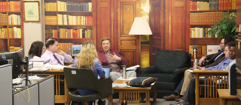 Faculty in a section of the library sitting down having a discussion