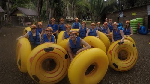 I-O psychology students posing with floating tubes while on their international trip