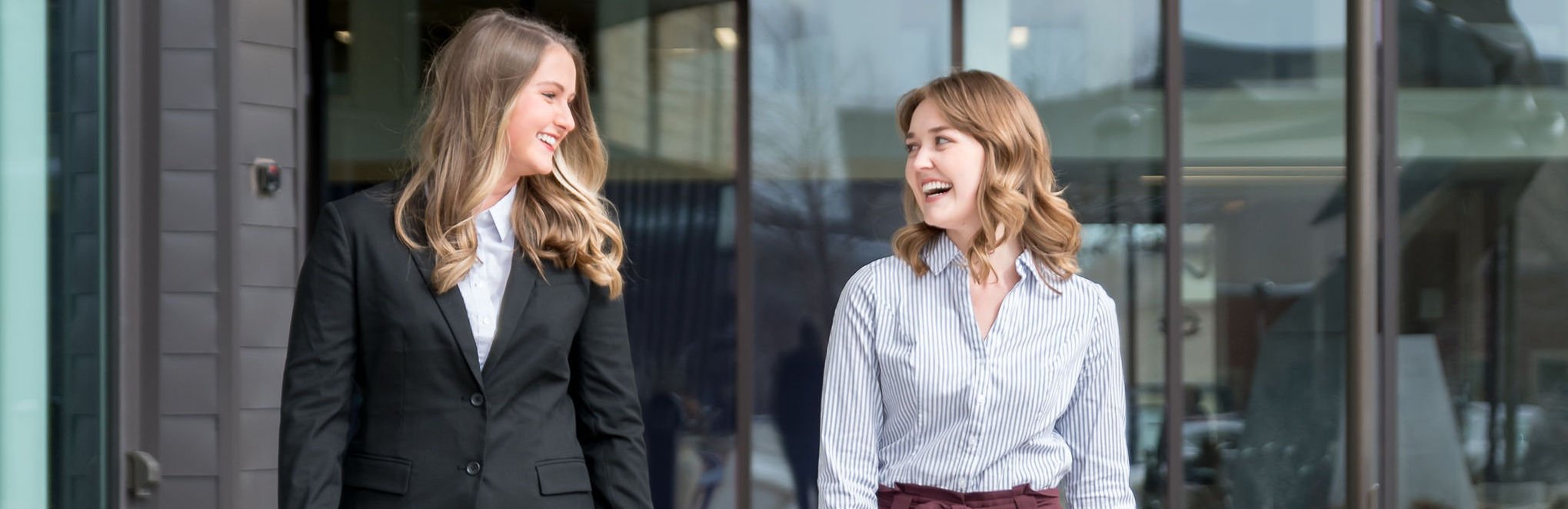 two women in formal attire laughing