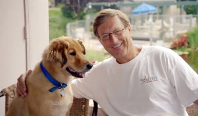 a person and dog sitting on a chair