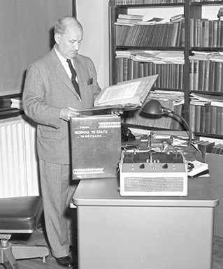 a person standing at a desk with a book