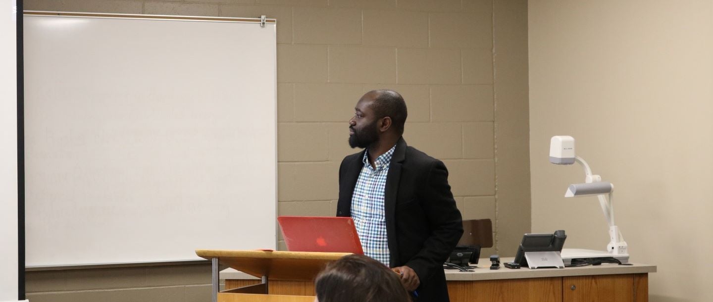 A graduate student presenting in a classroom