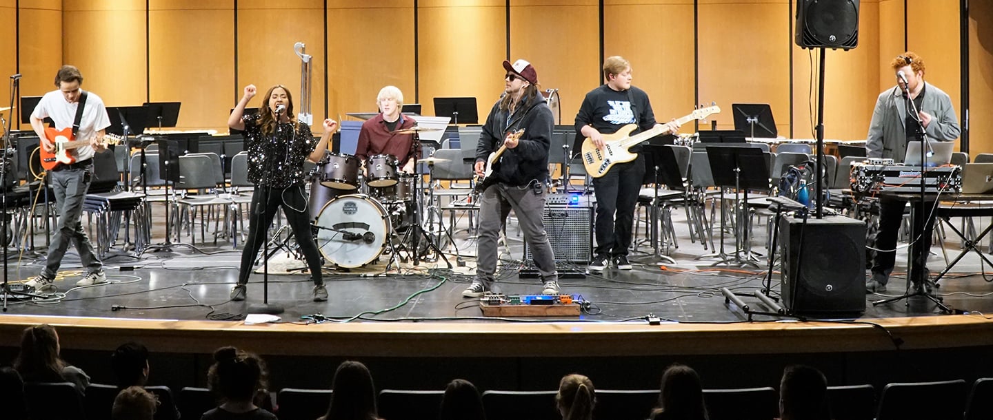 Students in Minnesota State University Contemporary ensembles performing in a stage infront of a crowd