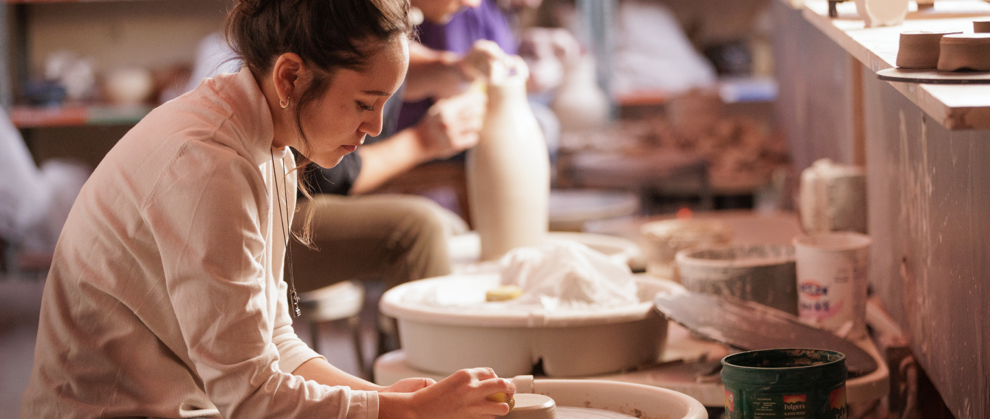 a person using a wheel to make a piece of clay